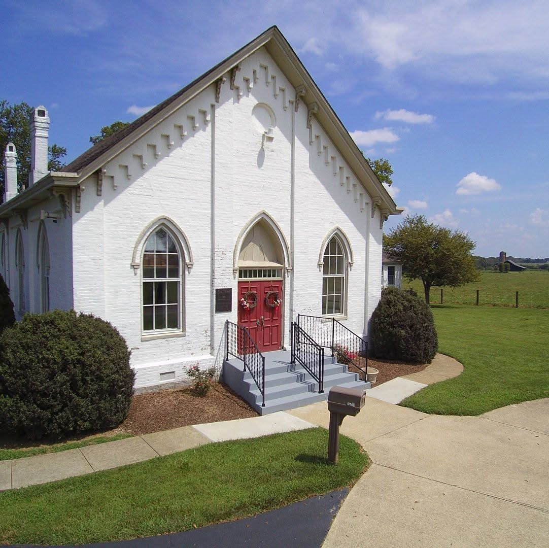 Salem Presbyterian Church front facade with red doors and Gothic arched windows