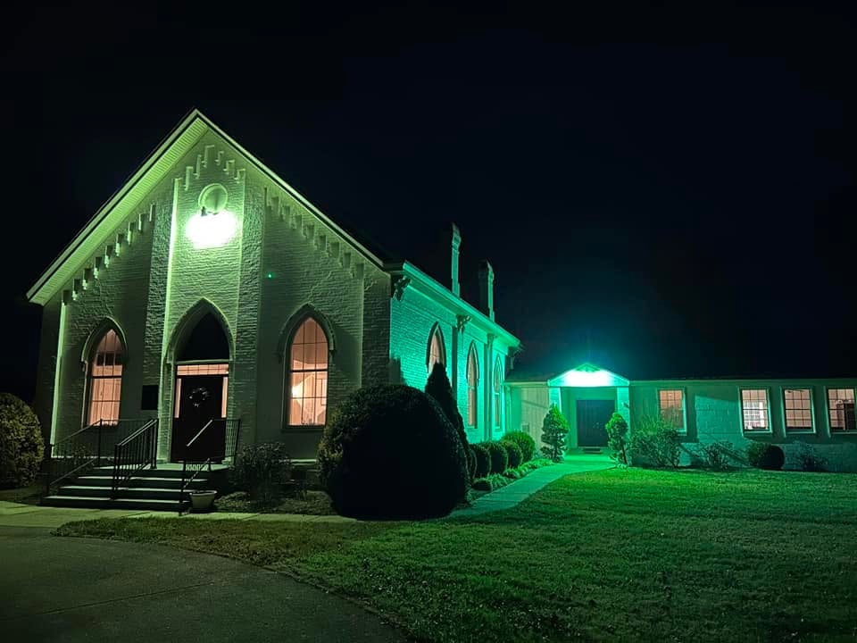 Salem Presbyterian Church lit up at night with green architectural lighting