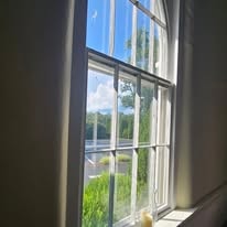 View through a tall arched window at Salem Presbyterian Church looking out to the countryside