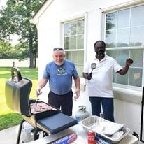 Two men grilling outdoors at a Salem Presbyterian Church cookout