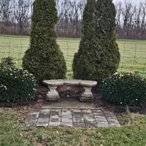 Salem Presbyterian Church memorial garden with stone bench and evergreen topiaries